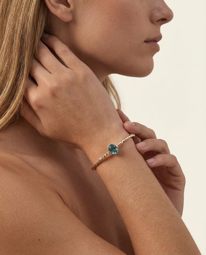 Twisted Gold Bangle with Oval Blue Topaz