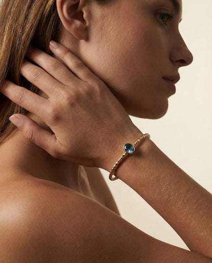 Twisted Gold Bangle with Oval Blue Topaz