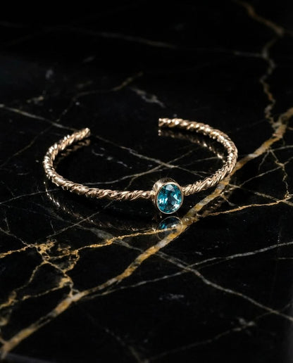 Twisted Gold Bangle with Oval Blue Topaz