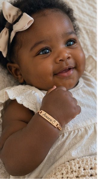 Smiling baby wearing custom name bracelet