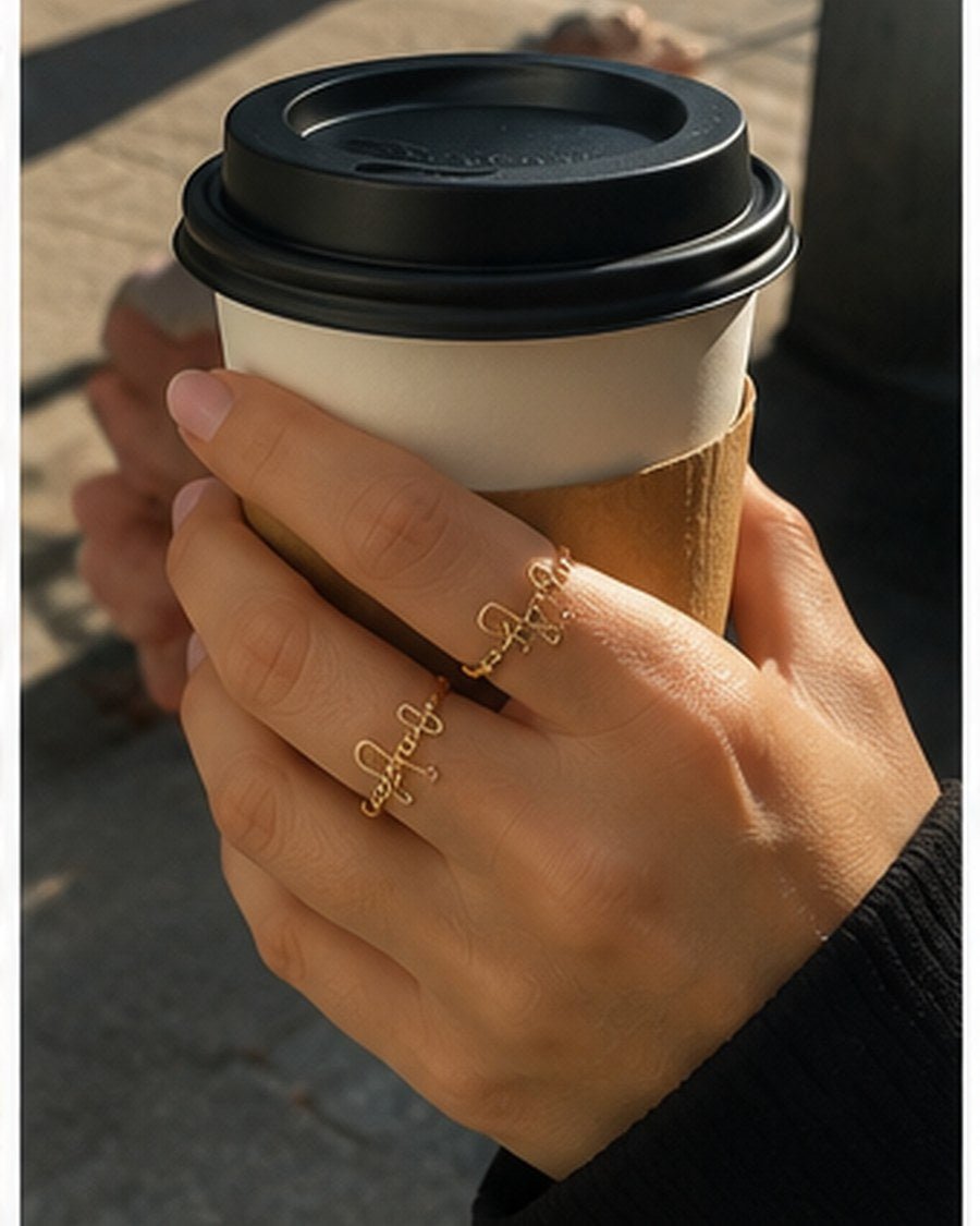Customer wearing custom name ring while holding coffee