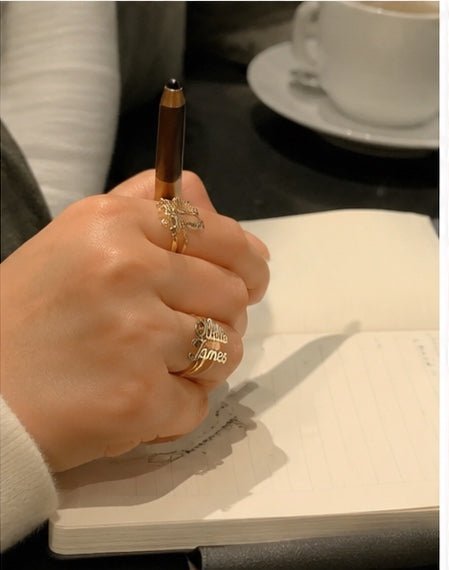 Customer wearing two name ring with iced coffee